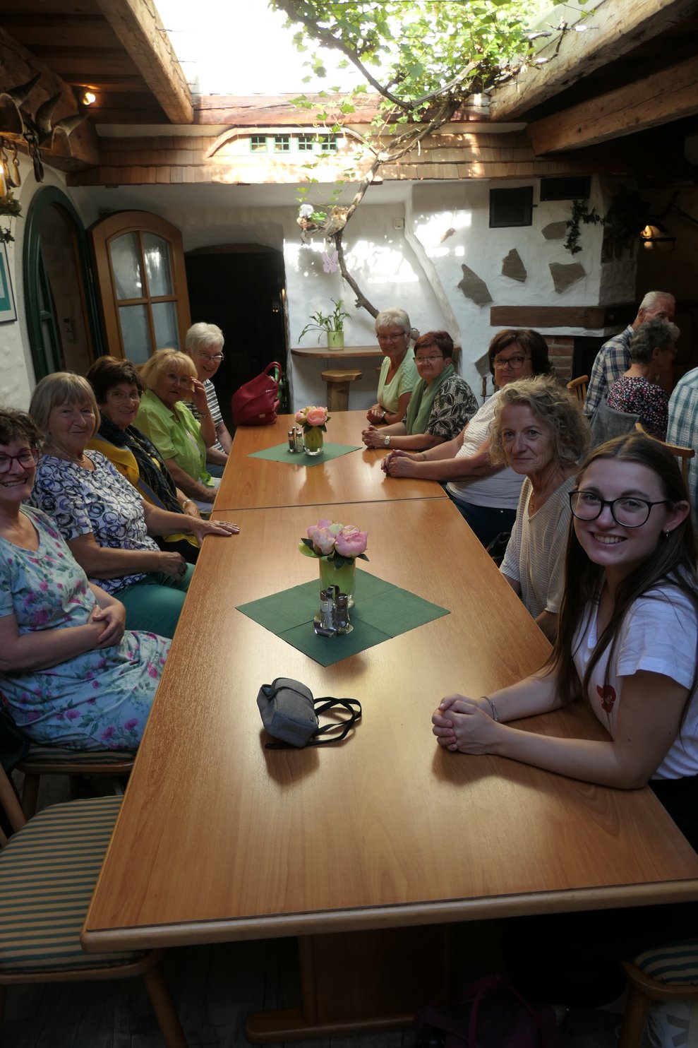 Damen und Herren am Heurigentisch sitzend