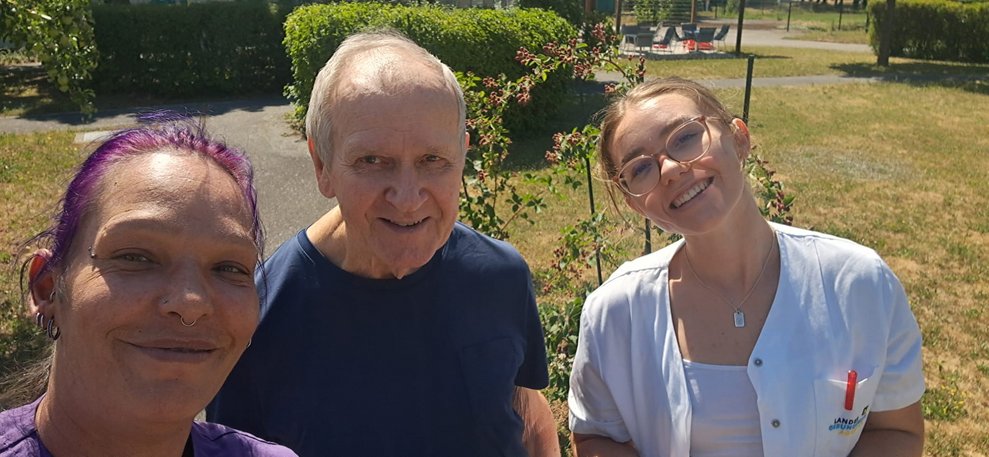 Gruppenfoto im Garten: Alltagsbegleiterin, Bewohner, Praktikantin