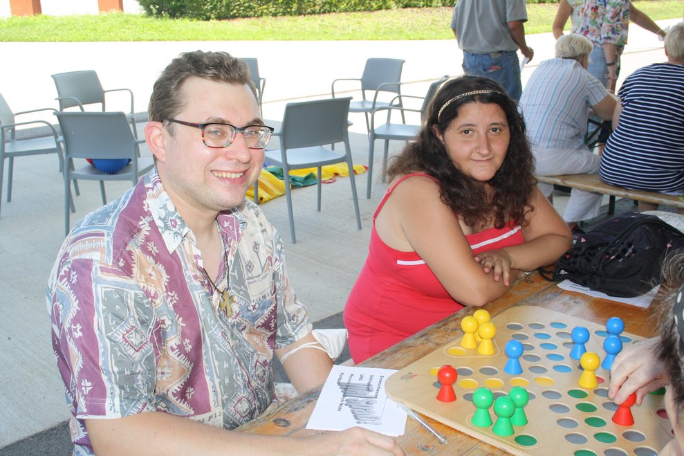 Personen sitzen bei einem Tisch und spielen