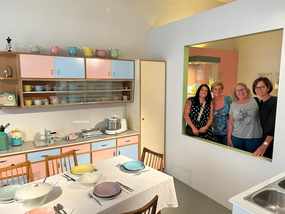 4 Personen lachen in die Ausstellung.