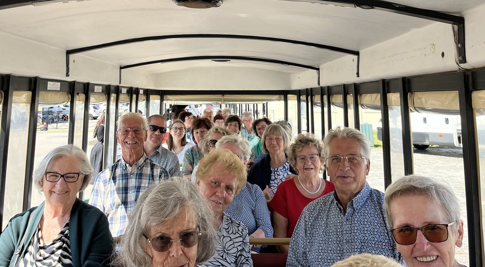 Viele Damen und Herren im Bummelzug