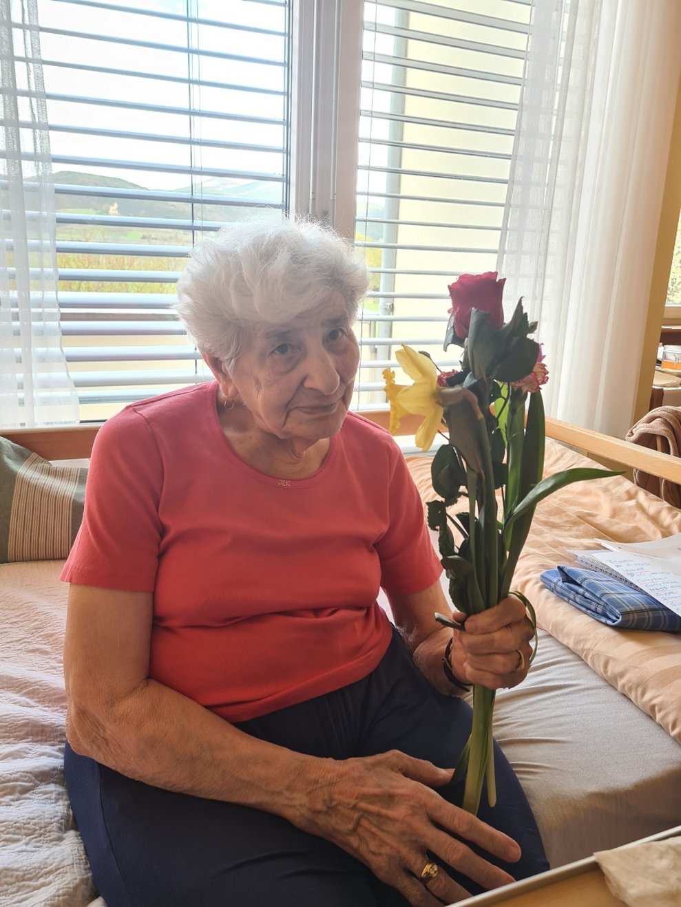 Eine Bewohnerin hält Blumen.