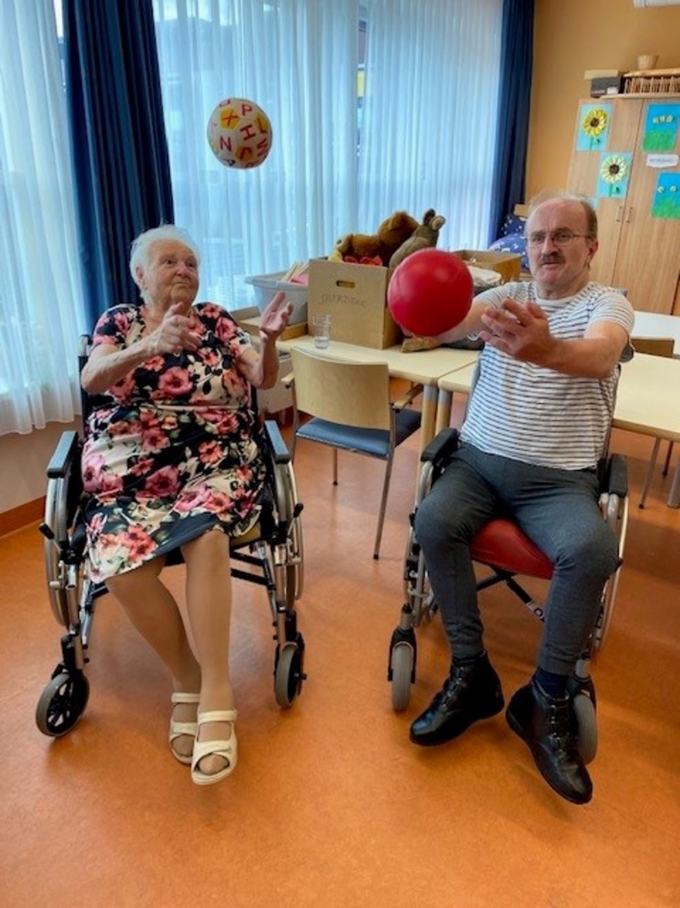 Bewohnerin und Bewohner schmeißen einen Ball in die Höhe 