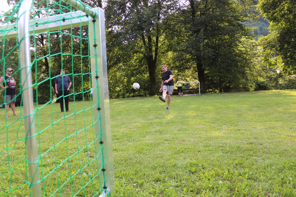Eine Person schießt einen Fußball in das Tor.