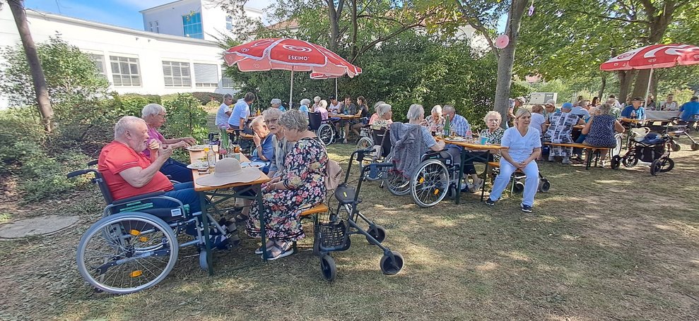Sitzende Personen beim Sommerfest.