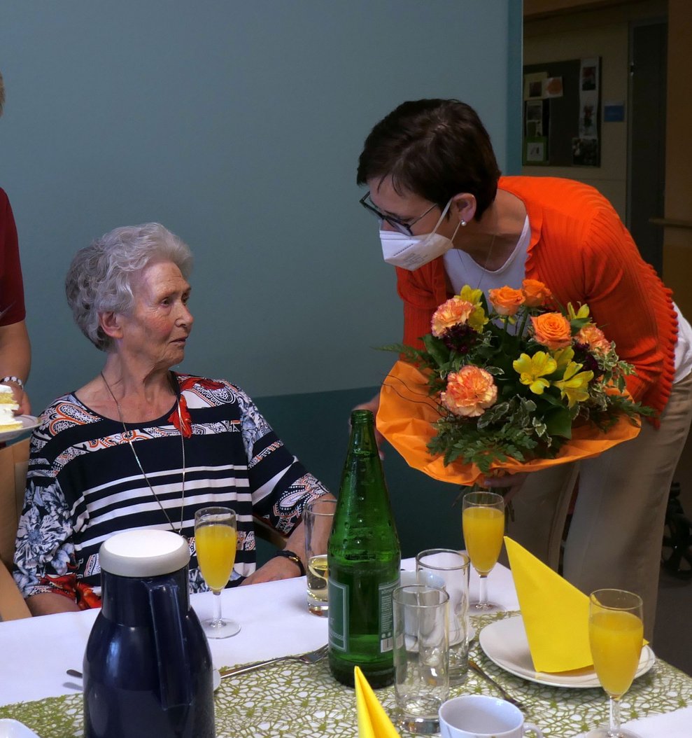 Zwei Damen mit einem Strauß Blumen.