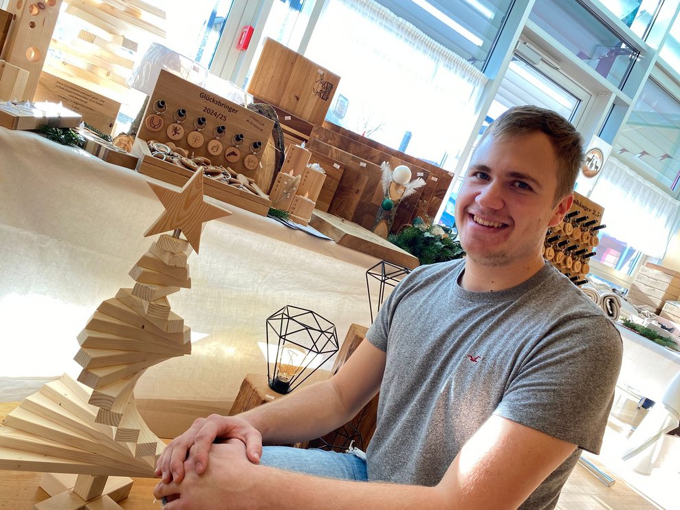 Mann vor seinem Stand mit Holzprodukten 