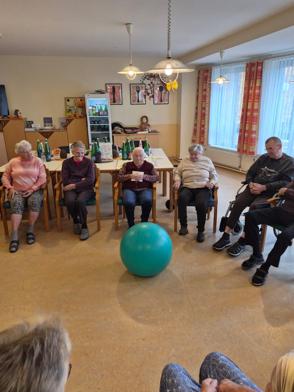 Sitzende BewohnerInnen bei der Bewegungsrunde. Peziball liegt auf Boden.