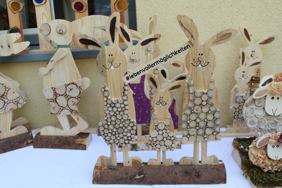 Drei Hasen aus Holz mit der Aufschrift "ein Leben voller Möglichkeiten"