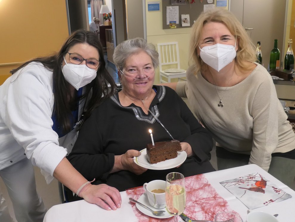 Drei Damen mit einem Stück Torte.