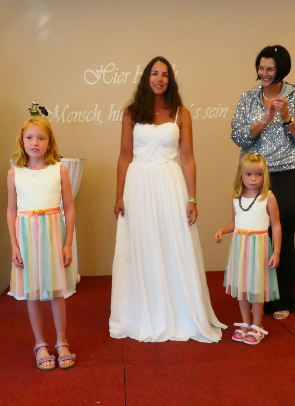 Eine Braut mit Zwei Mädels im Regenbogenkleid.