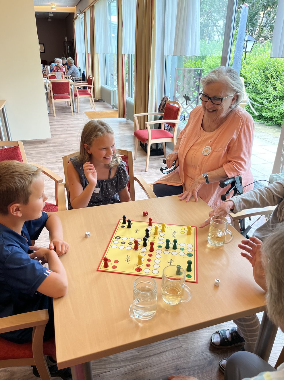 Kinder und Bewohner beim Brettspiel Mensch ärgere dich nicht