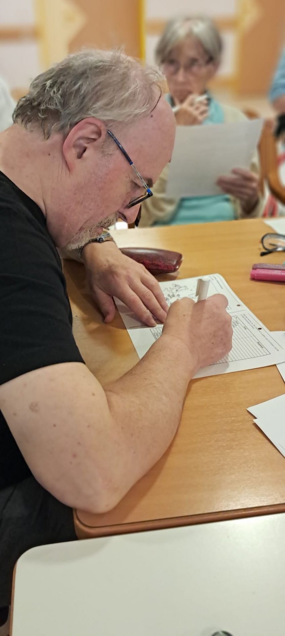 Bewohner beim Gedächtnistraining. Bewohner beim Schreiben.