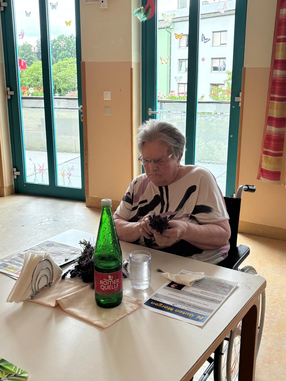 Bewohnerin hält kleinen Lavendelbuschen in der Hand.