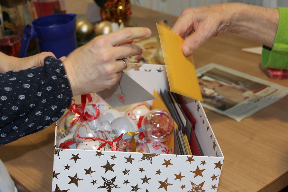 Eine Box gefüllt mit Christbaumkugeln und Weihnachtskarten.
