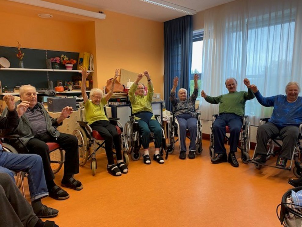 Bewohnerinnen und Bewohner heben die Hände