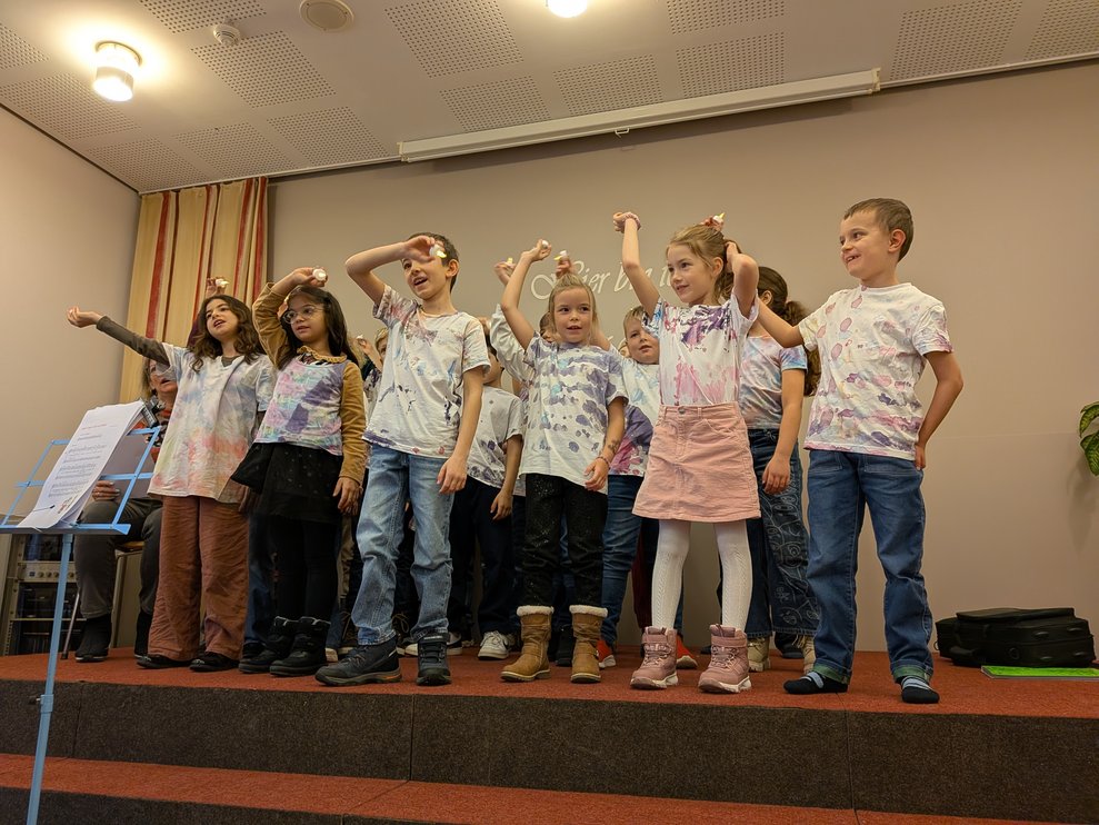 Die Kinder singen ein Lied mit LED Kerzen.