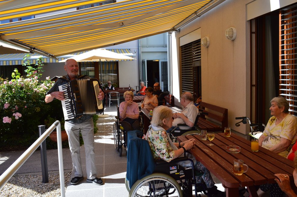 Ein Musiker und BewohnerInnen.