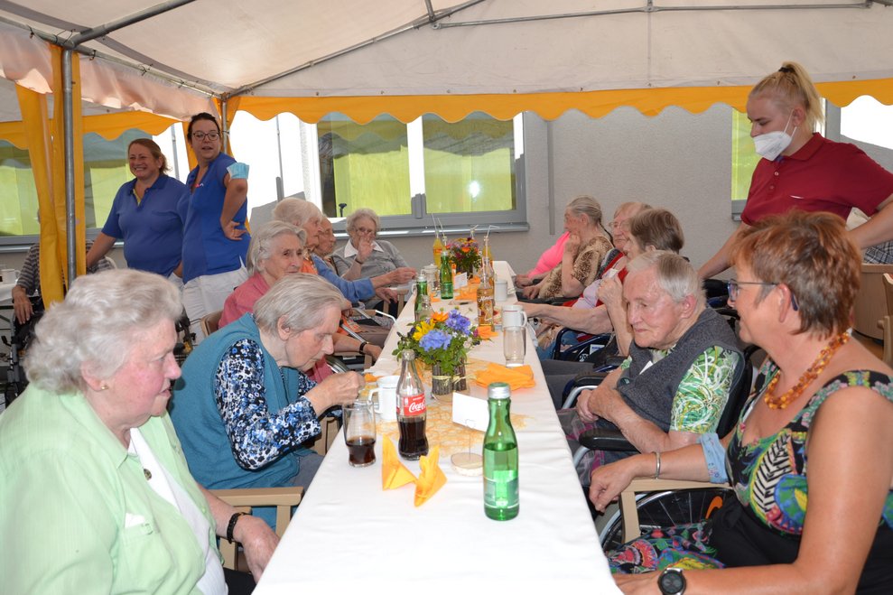 BewohnerInnen sitzen bei einem Tisch.