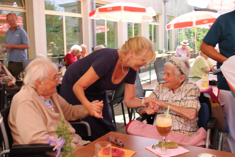 Bewohnerinnen schunkeln im Sitzen mit