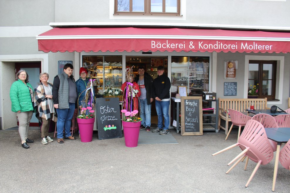 Mehrere Personen stehen vor einer Bäckerei.
