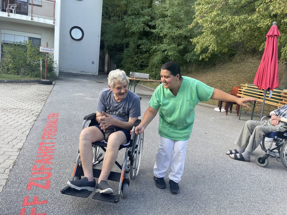 Ein Mann im Rollstuhl tanzt mit einer Frau. 
