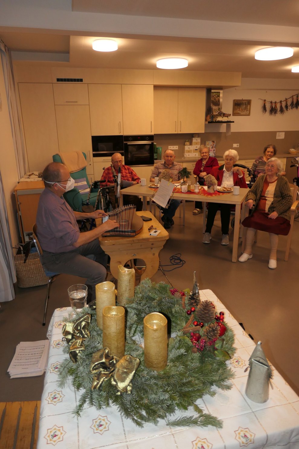 Mehrere Personen lauschen den Klängen der Zither