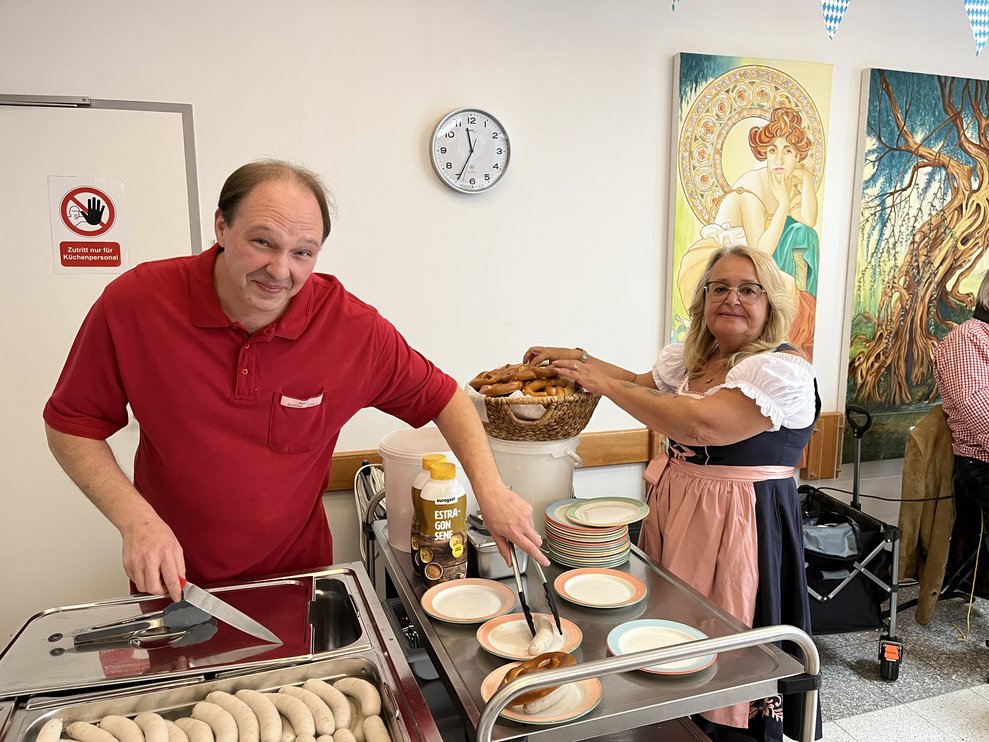 Mitarbeiter teilen Weißwurst aus