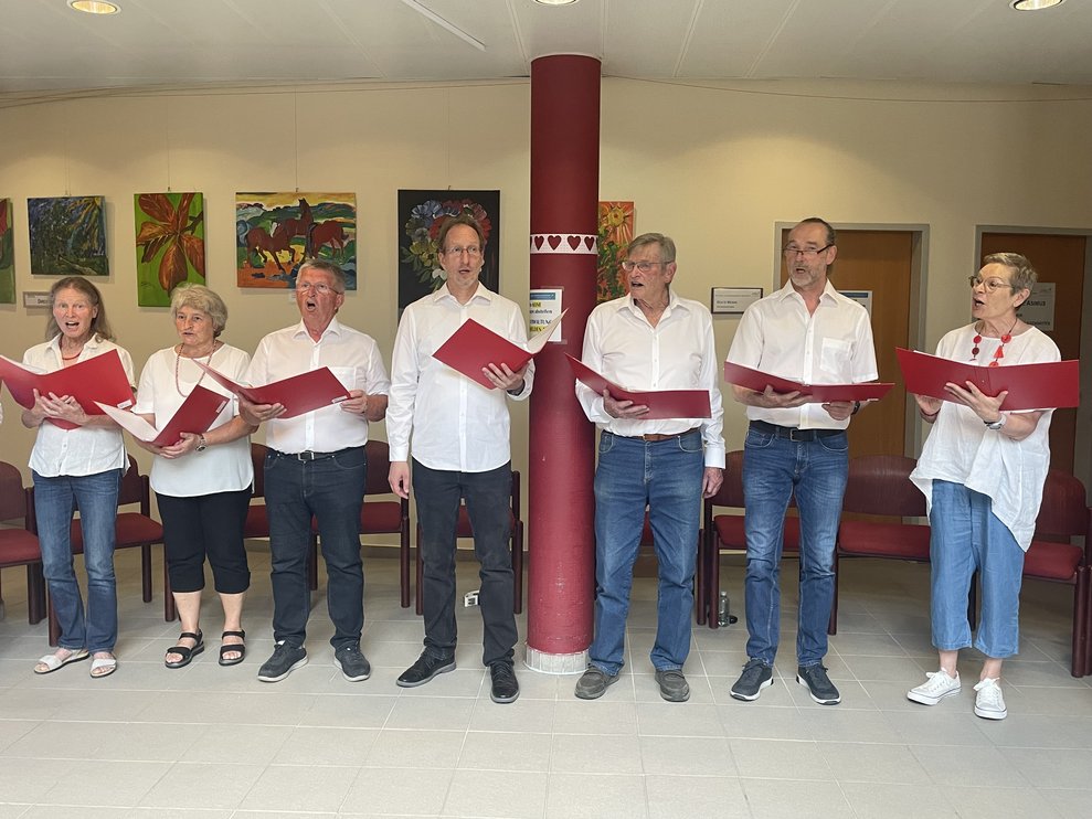Drei Frauen und vier Männer singen.
