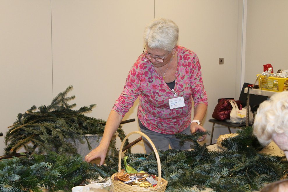 Frau beim Adventkranzbinden