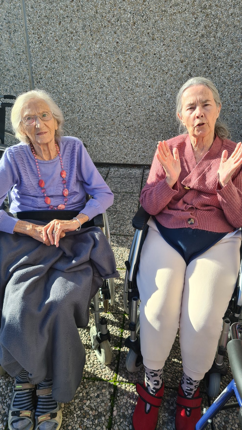 Die Bewohnerinnen genießen den sonnigen Tag auf der Terrasse.