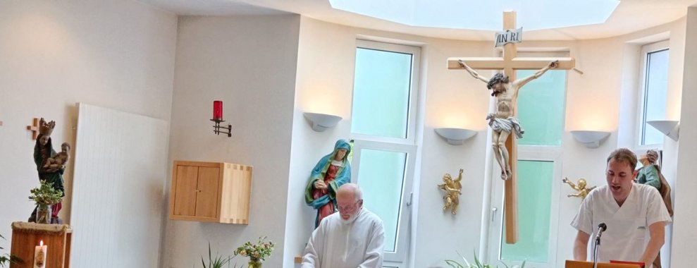 Zwei Männer stehend in der Hauskapelle beim Altar.