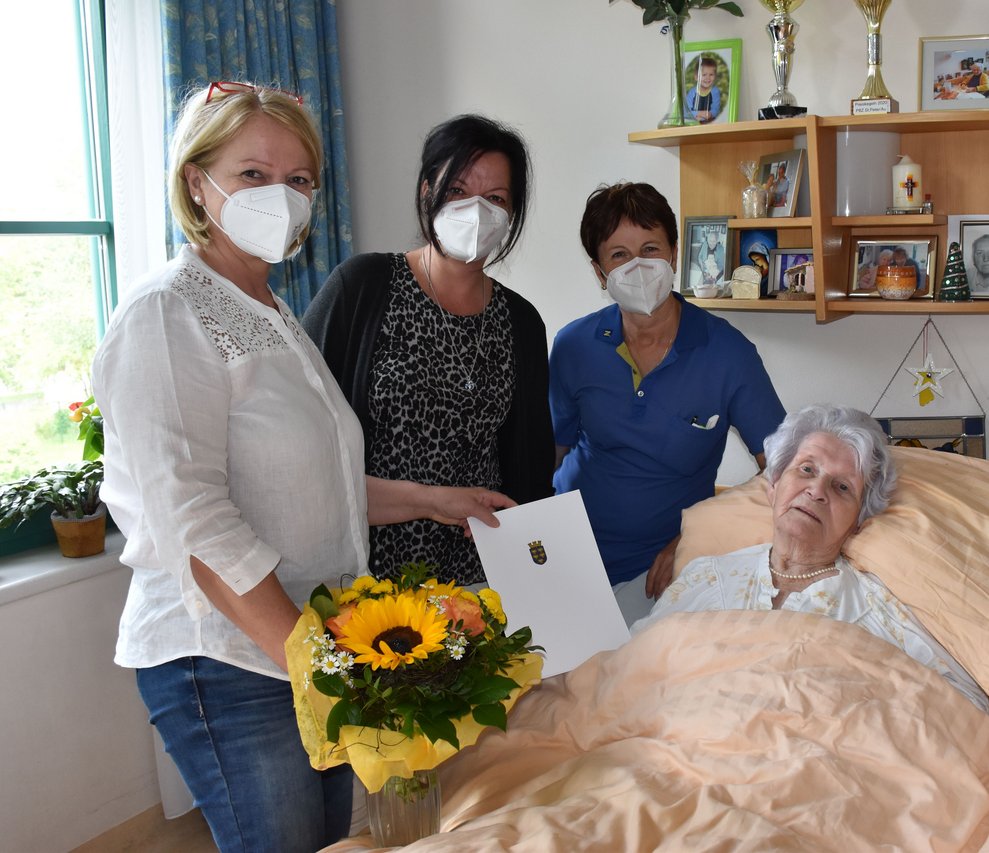 Personen stehen neben einer Bewohnerin