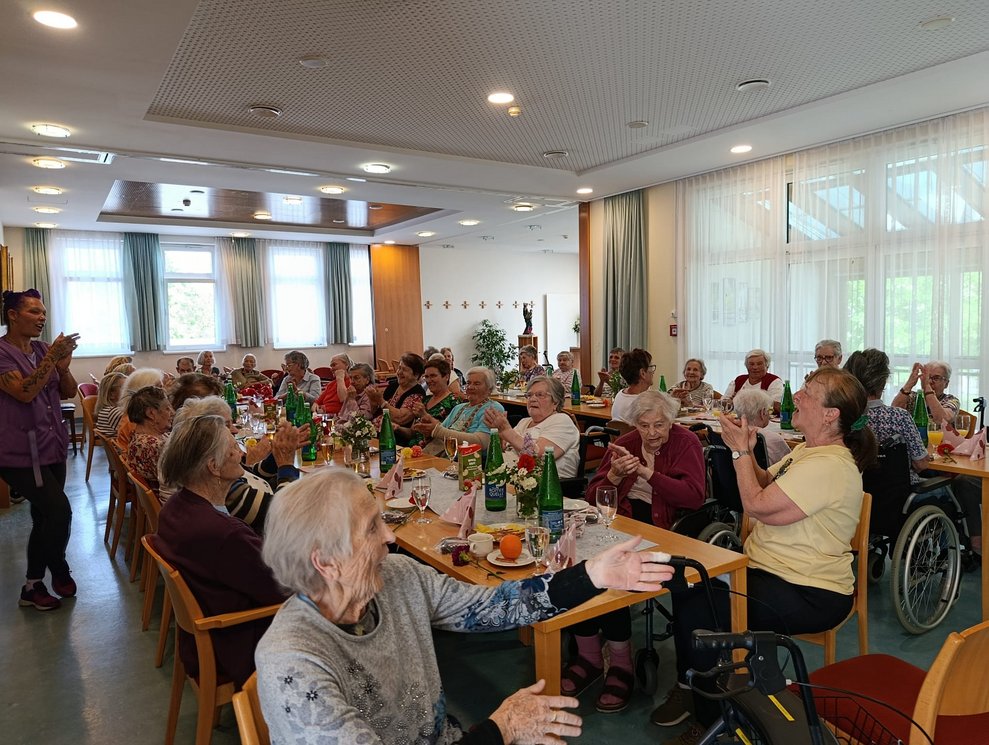 Personen beim Klatschen bei der Muttertagsfeier.
