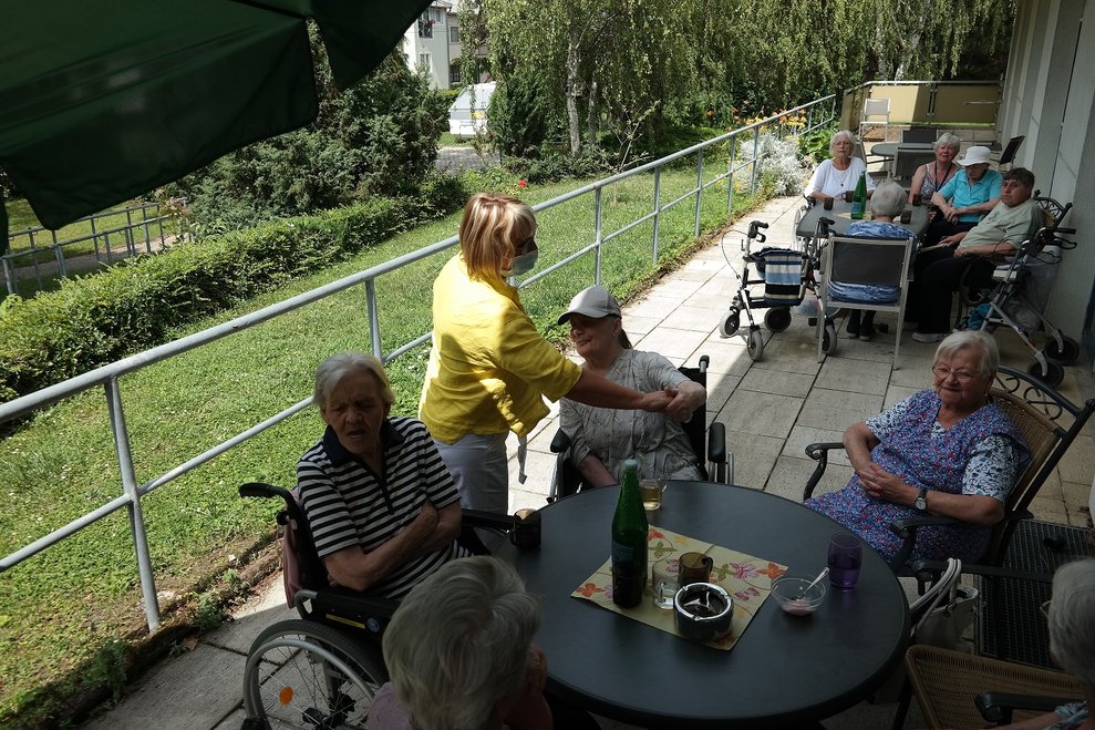 BewohnerInnen sitzen draußen.