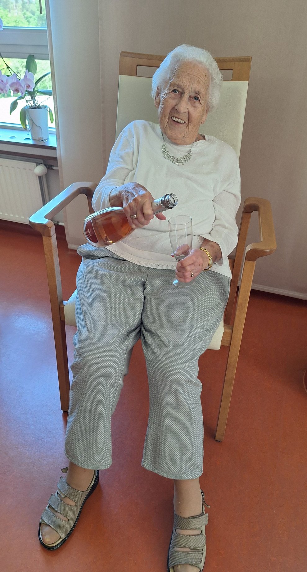 Bestens gelaunt lässt es sich unsere Jubilarin nicht nehmen, sich ihr Gläschen Sekt selber einzuschenken.