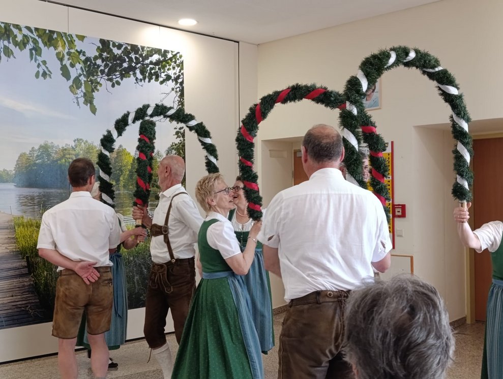 MitgliederInnen der Volkstanzgruppe Rosenburg/Mold tanzen mit Bögen.