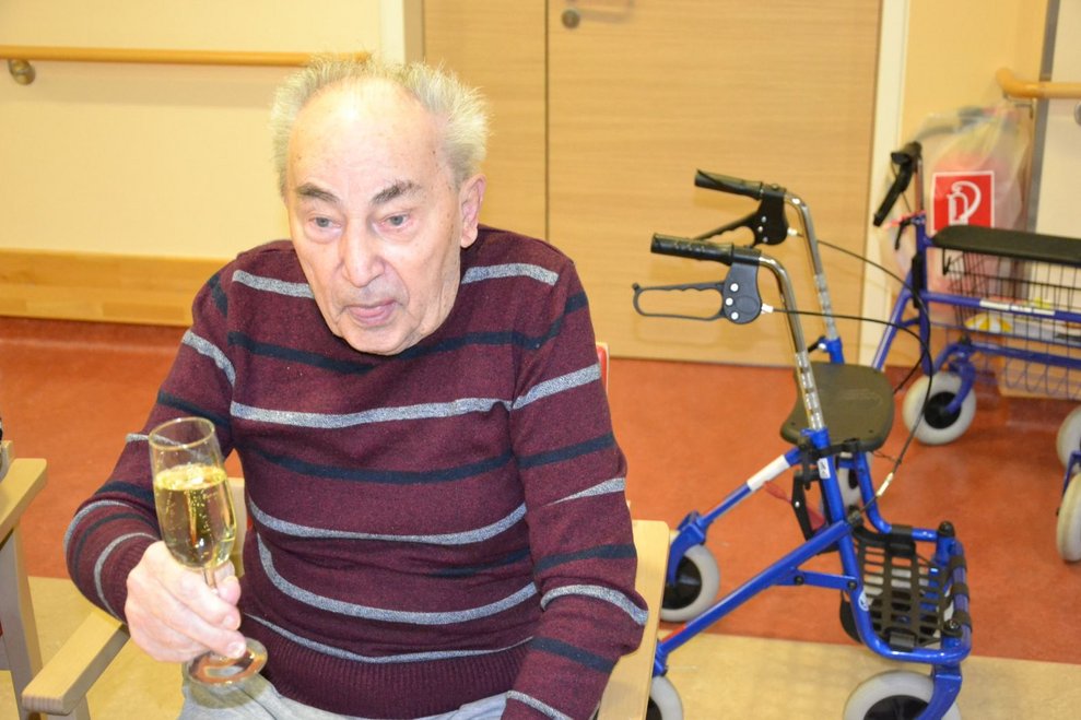 Ein Bewohner mit einem Sektglas.