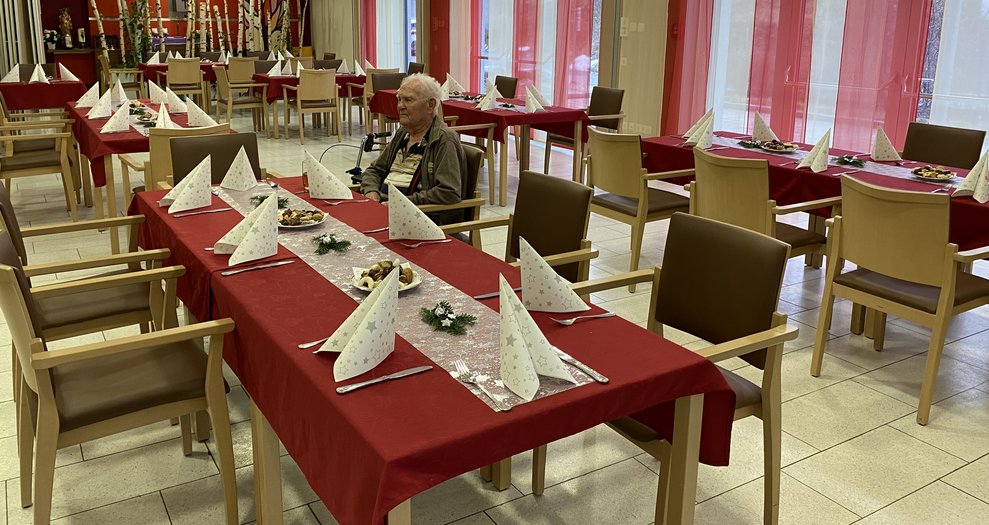 Die Tische sind weihnachtlich dekoriert und der erste Bewohner ist auch schon eingetroffen.