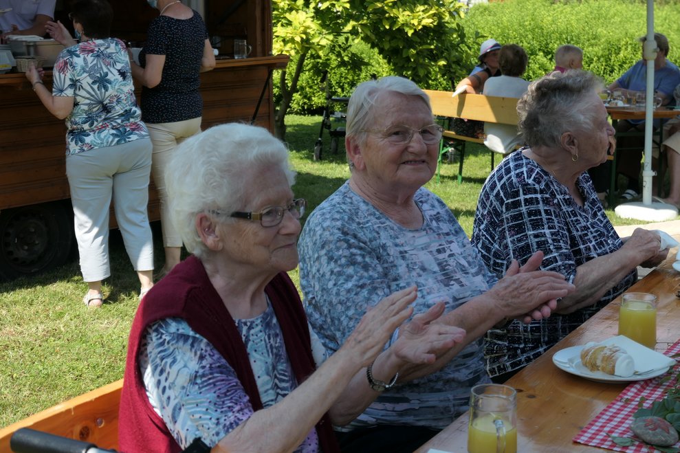 Drei Frauen klatschen mit.